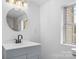 Stylish bathroom with a sleek vanity, round mirror, and natural light from the window at 612 E E St, Newton, NC 28658