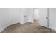 A simple, carpeted bedroom features fresh, white paint, closet, and doorway to the next room at 612 E E St, Newton, NC 28658
