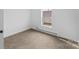 Simple bedroom with modern baseboard heaters, soft carpet and a view to the outside at 612 E E St, Newton, NC 28658