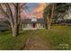 Charming single-story home with a red door, framed by trees and a concrete walkway at 612 E E St, Newton, NC 28658