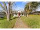 Charming single-Gathering home featuring a red front door, green lawn, and mature shade trees at 612 E E St, Newton, NC 28658