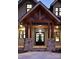 Elegant entryway with a wood and stone portico, double doors and lighting at 8058 Edgewater Dr, Norwood, NC 28128