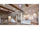 Open living room with stone fireplace, hardwood floors, and exposed wooden beams at 8058 Edgewater Dr, Norwood, NC 28128