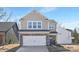 Two-story house with stone and shingle accents, two-car garage, and landscaping at 2033 White Cypress Ct # Kh06, Charlotte, NC 28216