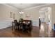 Charming dining room boasts hardwood floors, wainscoting and an elegant chandelier above the table set for six at 3006 Cricket Ln, Lancaster, SC 29720