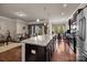 Open-concept kitchen with granite island and dark wood cabinets, seamlessly flowing into the living and dining areas at 3006 Cricket Ln, Lancaster, SC 29720