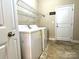 Bright laundry room featuring washer, dryer, wire shelving, and a door to the outside or garage at 3006 Cricket Ln, Lancaster, SC 29720