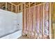 Bathroom in progress featuring a new white tub and framed walls with pink insulation at 4615 Yellow Poplar Ln, Concord, NC 28025