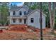 Two-story new construction home with light gray siding and black window frames ready for brick on a large wooded lot at 4615 Yellow Poplar Ln, Concord, NC 28025