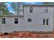 Gray horizontal siding adorns the side of this new construction home with black window frames and a brick foundation at 4615 Yellow Poplar Ln, Concord, NC 28025