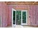 Unfinished room interior with open french doors showing wooded area and exposed insulation on walls at 4615 Yellow Poplar Ln, Concord, NC 28025