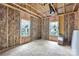 Unfinished room interior with exposed beams, insulation, plywood subfloor and two windows at 4615 Yellow Poplar Ln, Concord, NC 28025
