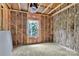 Unfinished room interior with exposed beams, insulation, plywood subfloor and window at 4615 Yellow Poplar Ln, Concord, NC 28025