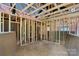 Unfinished room interior with exposed beams, insulation, plywood subfloor and stud framing at 4615 Yellow Poplar Ln, Concord, NC 28025