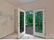White patio doors in an unfinished room showcasing a view of trees and the backyard at 4641 Yellow Poplar Ln, Concord, NC 28025