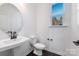 Modern half bathroom with dark wood floor and round mirror at 1194 Lost Cove Rd, Indian Land, SC 29707