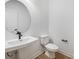 Modern powder room with a round mirror and pedestal sink at 1198 Lost Cove Rd, Indian Land, SC 29707