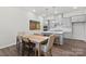 Dining area with light wood table and gray kitchen in the background at 1198 Lost Cove Rd, Indian Land, SC 29707