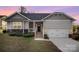 Charming home featuring stone accents, an attached garage, and meticulously maintained landscaping at 159 Rubys Way # 35, Oakboro, NC 28129