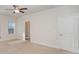 An empty main bedroom with neutral carpet, ceiling fan, and a bathroom through a doorway at 159 Rubys Way # 35, Oakboro, NC 28129