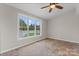 Bright room with tile flooring, neutral walls, a ceiling fan, and three windows overlooking the backyard at 307 Tara Elizabeth Pl # 22, Kannapolis, NC 28083