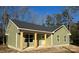 Newly constructed home with light green vinyl siding, a covered porch, and wood posts at 3537 Taxahaw Rd, Lancaster, SC 29720