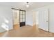 Bedroom with hardwood floors, barn door to closet, and access to hallway at 716 Ellsworth Rd, Charlotte, NC 28211