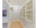 Walk-in closet with built-in shelves and hanging rod at 716 Ellsworth Rd, Charlotte, NC 28211