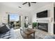 Cozy living room with a fireplace, ceiling fan and a sliding glass door to a private balcony at 907 Southwest Dr, Davidson, NC 28036