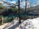 View of an outdoor wooden deck overlooking a quarry lake with turquoise water, trees, and blue sky at 111 Sentinel Ct, Mooresville, NC 28115