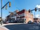 Street corner view of brick buildings, vintage signs, and traffic lights, with cars driving down the street on a bright day at 111 Sentinel Ct, Mooresville, NC 28115