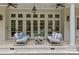 Elegant back porch features neutral furniture, ceiling fans, and beautiful views of the grounds at 1579 Queens W Rd, Charlotte, NC 28207