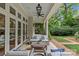 Covered back porch features comfortable seating and elegant touches at 1579 Queens W Rd, Charlotte, NC 28207