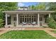 Charming back porch with neutral furniture, ceiling fans, and beautiful columns overlooking a lush yard at 1579 Queens W Rd, Charlotte, NC 28207