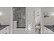 Bathroom featuring a glass shower, black hardware, a white vanity, mosaic floors, and natural light at 1579 Queens W Rd, Charlotte, NC 28207