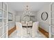 Classic dining room featuring wainscoting, stylish chandelier, and backyard access at 1579 Queens W Rd, Charlotte, NC 28207