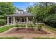 Landscaped backyard featuring a lovely covered porch and manicured gardens at 1579 Queens W Rd, Charlotte, NC 28207