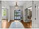 Bright foyer featuring hardwood floors, transom windows, chandelier, and doorway views at 1579 Queens W Rd, Charlotte, NC 28207
