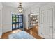 Inviting foyer features hardwood floors, chandelier, glass-paned doors, and views into the living room at 1579 Queens W Rd, Charlotte, NC 28207