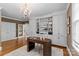 Spacious home office featuring custom built-ins, natural light, and a modern chandelier at 1579 Queens W Rd, Charlotte, NC 28207