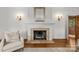 Bright living room featuring a marble fireplace, decorative sconces and gleaming hardwood floors at 1579 Queens W Rd, Charlotte, NC 28207