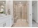 Modern bathroom with a glass-enclosed shower, double vanity, and neutral tile at 1618 Village Grove Ln, Monroe, NC 28110