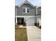 Charming townhome featuring a one-car garage, stylish gray siding and a well manicured lawn at 1618 Village Grove Ln, Monroe, NC 28110