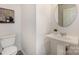 Well-lit half bathroom featuring a pedestal sink and modern fixtures at 1708 Holliford Ct, Charlotte, NC 28215