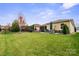 Landscaped backyard, showcasing a large grassy area and patio at 5003 Looking Glass Trl, Denver, NC 28037