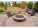 Landscaped backyard with fire pit and seating wall at 5003 Looking Glass Trl, Denver, NC 28037