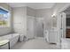 Tranquil bathroom featuring a freestanding tub, glass-enclosed shower, vanity, and tiled flooring at 511 E Main St, Rock Hill, SC 29730