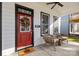 Inviting front porch with a red door, decorative wreath, and cozy seating area at 511 E Main St, Rock Hill, SC 29730