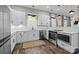 Well-lit kitchen with stainless steel appliances, white cabinets, hardwood floors, and quartz countertops at 511 E Main St, Rock Hill, SC 29730