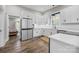 Bright kitchen featuring white cabinets, stainless steel appliances, and hardwood flooring at 511 E Main St, Rock Hill, SC 29730